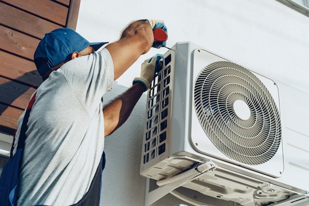 Imagem homem fazendo reparados em ar condicionado externo