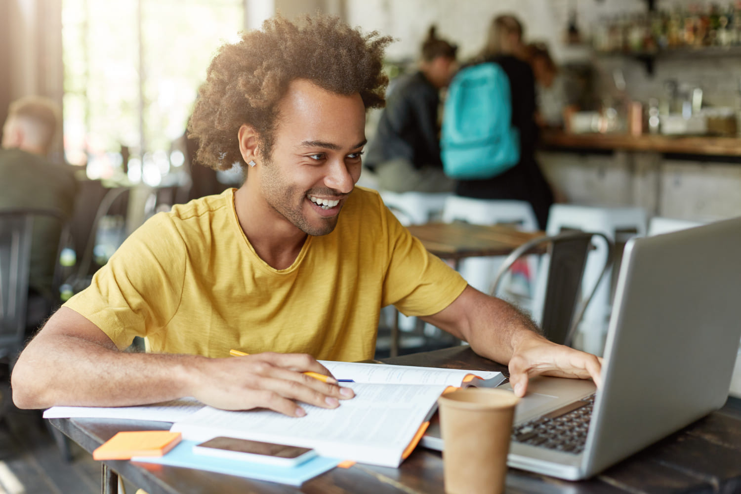 estudante com notebook e livros estudando em um ambiente apropriado